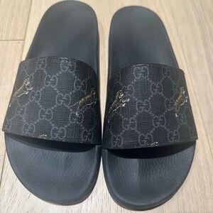 GUCCI men’s GG supreme tiger slides.